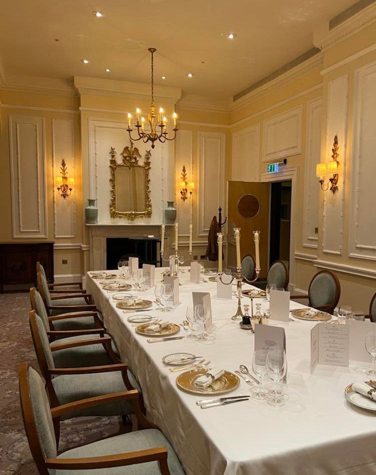 A long dining table laid for a Carver executive dinner at the Savoy
